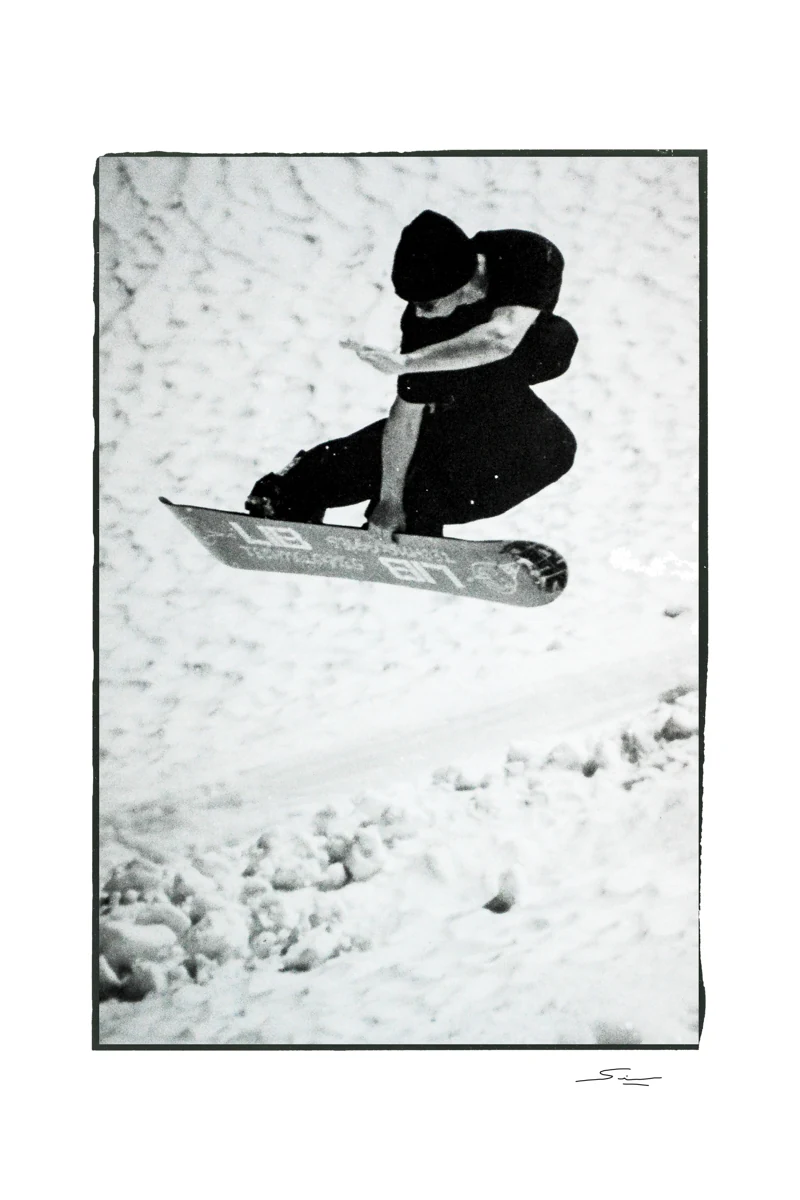 Jamie Lynn performing a method air at Blackcomb, British Columbia, photographed in black and white by Sean Sullivan, with the full original white border